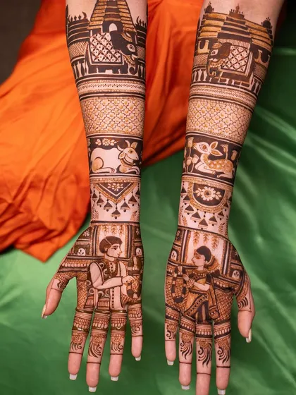 A full view of a custom two-states bridal mehendi, blending traditions from Karnataka and Tamil Nadu. You can see the distinct cultural elements on each arm, creating a cohesive yet unique story.