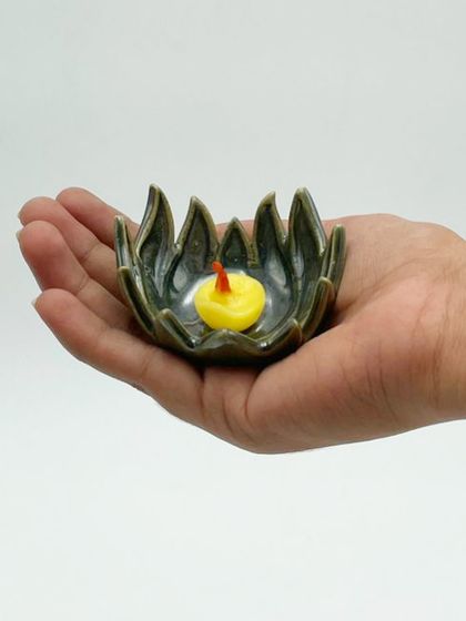 A close-up of our small, handcrafted lotus diya held in the palm of a hand. Its delicate shape and glaze make it a beautiful and meaningful addition to your Diwali puja or home decor.