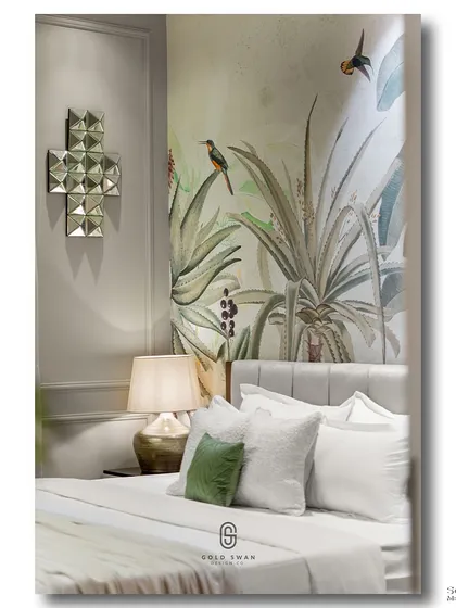 A serene bedroom corner where a muted tropical wallpaper is complemented by a geometric mirror and a soft green pillow. The composition is calm and balanced, showcasing a sophisticated use of pattern and texture.