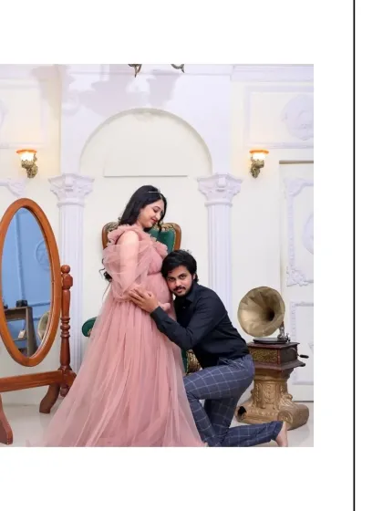 A classic and heartwarming pose. The father-to-be kneels to listen to the baby bump, a gesture of love and connection. The vintage props and elegant setting elevate this tender moment.