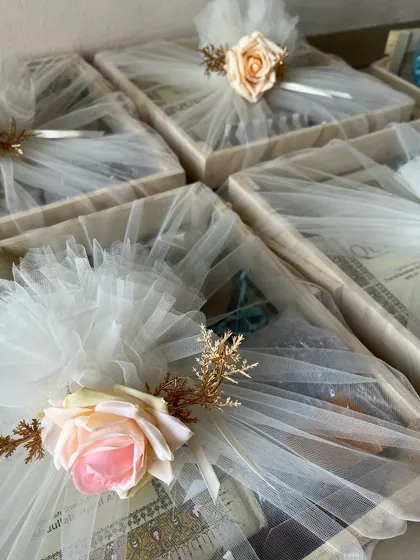 A closer look at the beautifully wrapped Ramadan gift trays, adorned with artificial roses and delicate tulle.