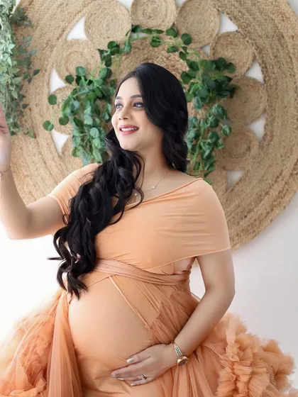 A glowing mommy-to-be looking off into the distance, perhaps dreaming of the future. The peach gown and natural light create a soft and beautiful portrait.