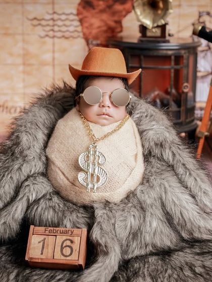 A fun and playful take on the traveler theme, with a tiny hat, sunglasses, and a dollar sign chain. We love adding a touch of humor and personality to our creative shoots.