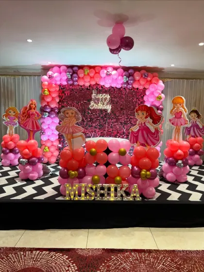 This Barbie and princess-themed stage is all about pink and sparkle. We used a sequin backdrop, themed balloon columns, and character cutouts to create a glamorous setting for the birthday girl, Mishika.