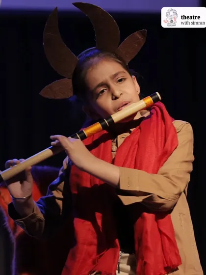 A young actor plays the flute as Mr. Tumnus in our Narnia adaptation, showcasing the many talents of our students.