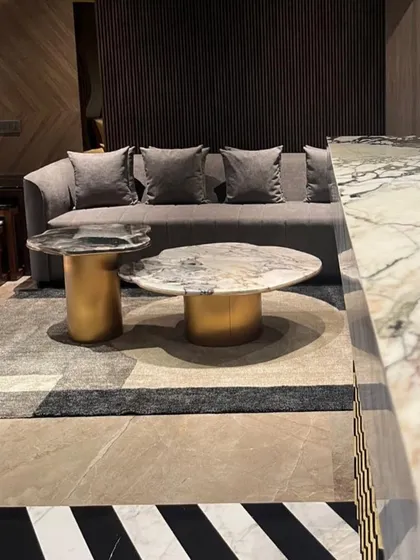 The living space in this Juhu apartment features a bold black-and-white striped marble floor. I balanced this strong element with soft grey upholstery and metallic accents for a sophisticated, modern look.