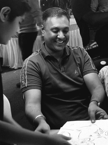 A guest's happy smile as he receives his finished caricature, a great example of client satisfaction at an event.