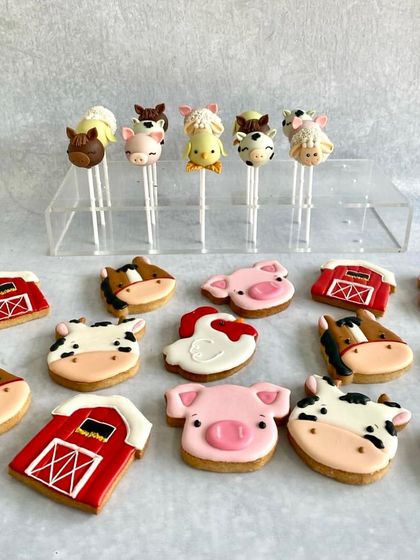 A set of adorable farm animal-themed cake pops and cookies. We made little pigs, cows, horses, and sheep to create a fun barnyard party.
