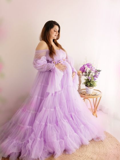 A beautiful, classic maternity pose. The soft, diffused light and pastel colors create a dreamy and romantic atmosphere.