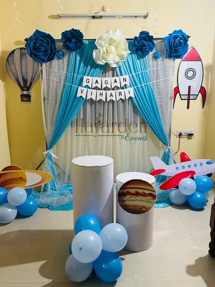 A creative and budget-friendly space theme for a home party. I used drapes and various cutouts like a rocket, planet, and hot air balloon.