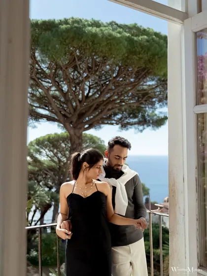 A quiet moment on a balcony overlooking the Italian coast. This frame captures the stylish elegance of the couple and the stunning sea view, embodying the essence of a luxurious European pre-wedding experience.