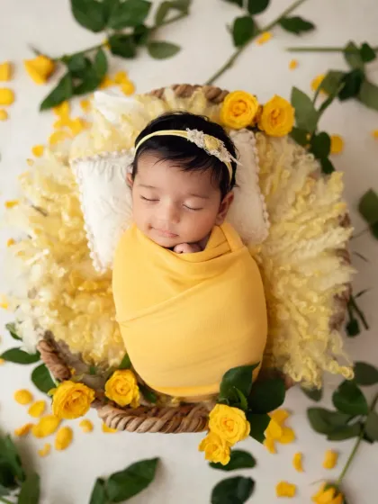 A beautiful newborn girl surrounded by sunshine yellow roses. I love using fresh, vibrant colors to create cheerful and memorable setups.