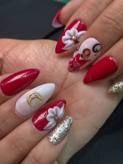 A glamorous Karva Chauth set with a classic red and white theme, featuring 3D flowers, a glittery accent nail, and a hand-painted design.