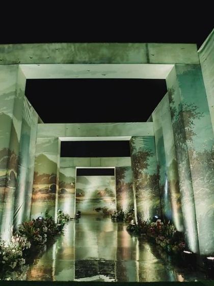 The entryway sets the tone for the entire event. For this reception, we created a dramatic pathway with walls featuring hand-painted landscapes, leading guests into a world of our creation.