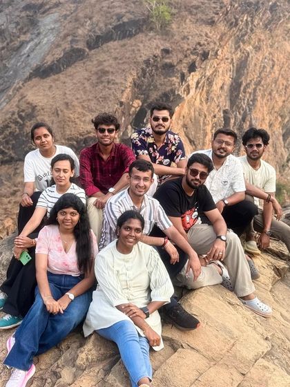 Taking a break on the rocky cliffs during the Gokarna beach trek, with great views of the coastline.