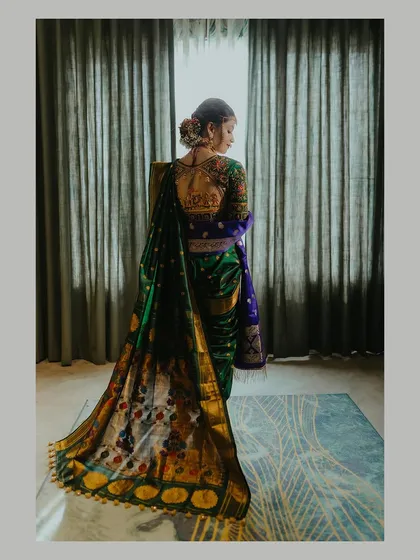 An elegant back shot of a bride in her Paithani saree, showcasing the intricate embroidery of her blouse and the traditional hairstyle.