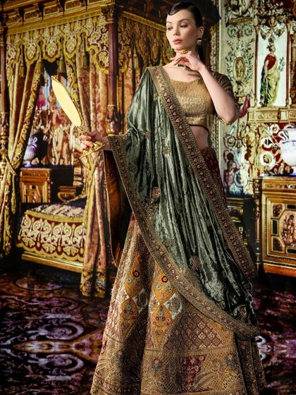 A majestic palace bedroom is projected to create a fairy-tale scene. The lighting is warm and opulent, matching the luxurious feel of the room and the model's ethnic wear.