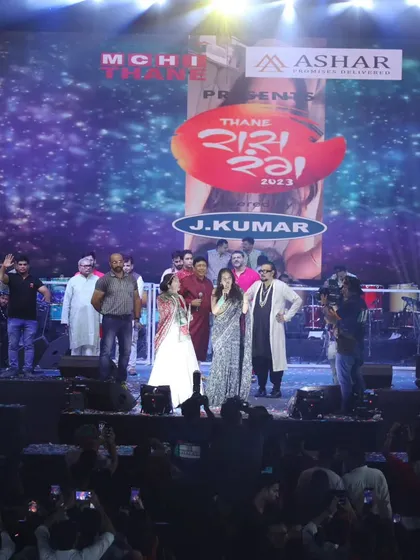 A wide shot showing the massive crowd and the entire panel on stage during the celebrity visit at Raas Rang Thane.