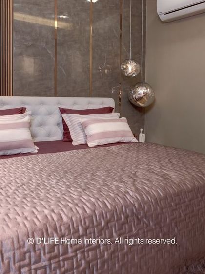 A serene bedroom design with a tufted headboard against a dark, textured wall. The spherical pendant lights add a soft, ambient glow to the space.