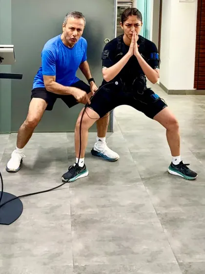 Our founder guides a client through her EMS workout, ensuring perfect form. This personalized attention is key to getting the most out of every 20 minute session.