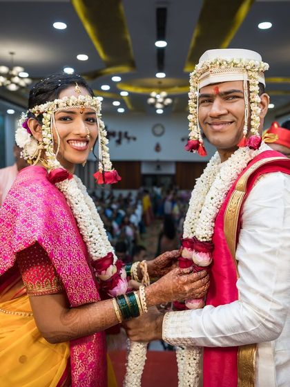 The happy couple, Anagha and Mihir, during their garland exchange ceremony, a pivotal moment in their Maharashtrian wedding.