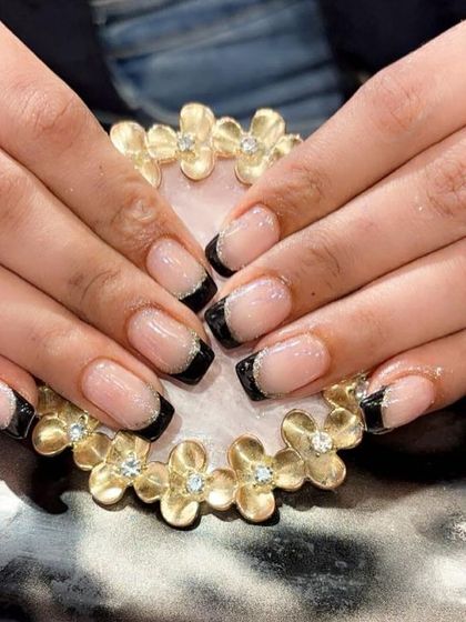 A chic and edgy look using black French tips with a fine silver glitter line on shorter, square-shaped nails.