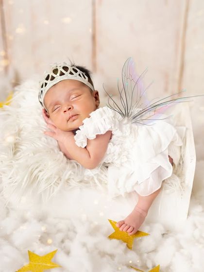 Twinkle, twinkle, little star. This photo captures the magic of childhood with a celestial theme, complete with fairy wings and a sky full of golden stars.