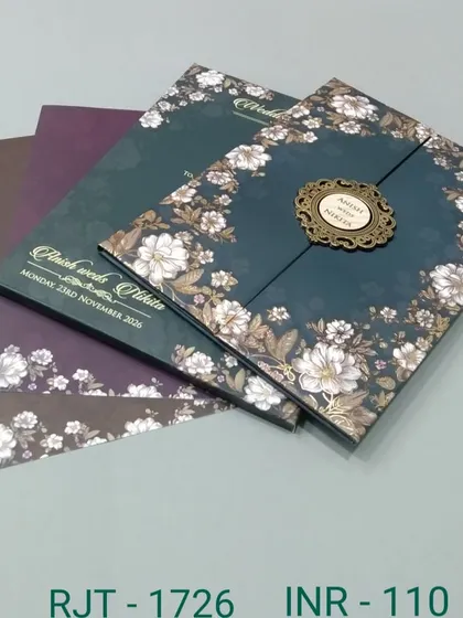 A dark teal gate-fold invitation featuring a border of white flowers. This design is available with inserts in various coordinating colors for a complete stationery suite.