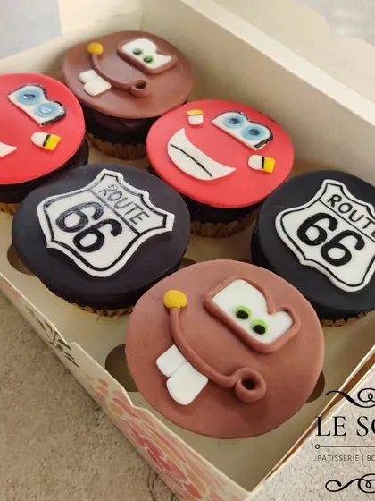 Kachow! These cupcakes were for a huge 'Cars' movie fan. I created fondant toppers featuring Lightning McQueen, Mater, and the iconic Route 66 sign. These are always a hit for kids' birthday parties.