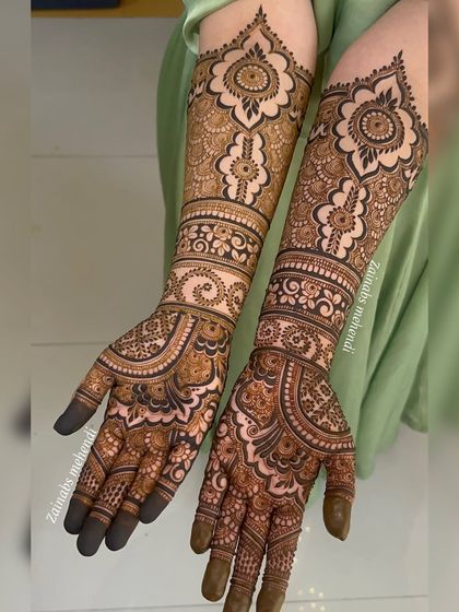 Symmetrical bridal henna for Maheen, with both hands adorned in a beautiful pattern that extends up the arms.