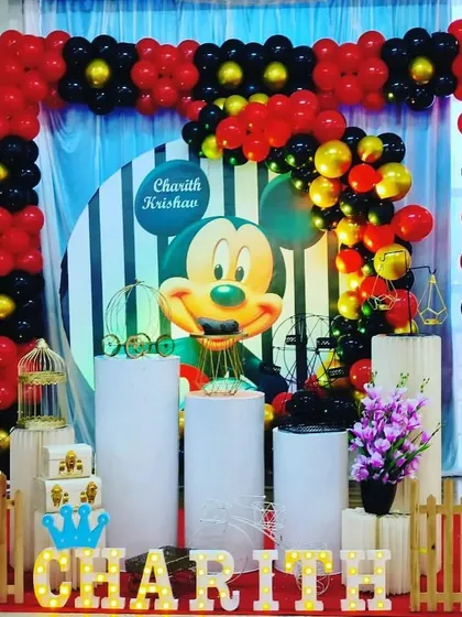 A classic Mickey Mouse theme with a red, black, and yellow color scheme. The stage features a large Mickey graphic, a balloon arch, and themed plinths.