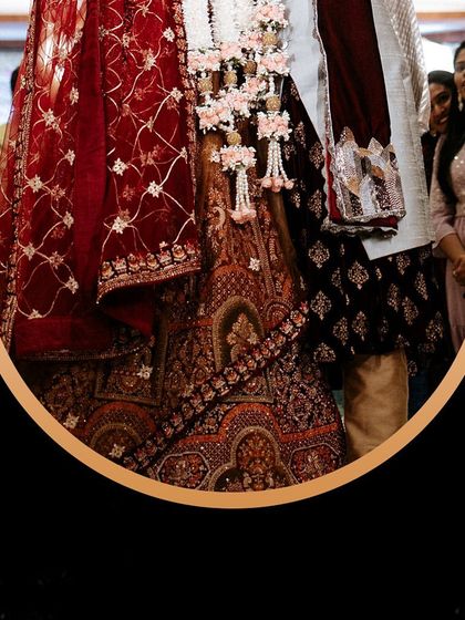 A close-up of the couple's traditional wedding outfits, showcasing the rich textures and intricate embroidery.