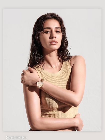 A campaign shot for Calvin Klein watches. The wet-look hair and sun-kissed makeup on Disha Patani create a fresh, editorial feel that is both modern and timeless.