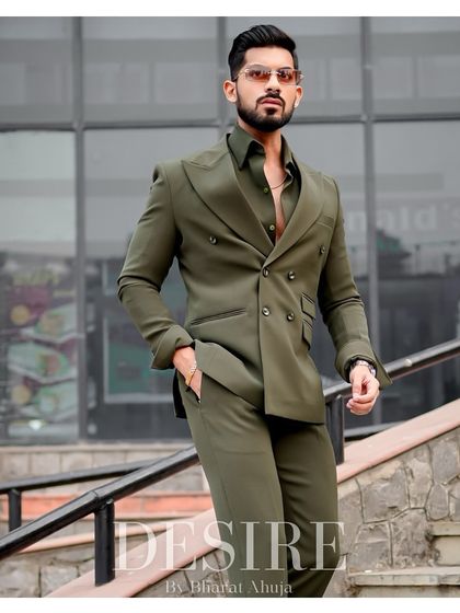 A powerful, full-length shot of the olive green suit. The double-breasted cut and rich color make it a standout piece for any formal occasion.