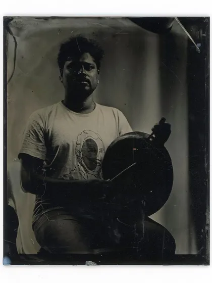 A wet plate collodion portrait capturing a musician with his handpan, showcasing the deep shadows and detailed highlights of the ambrotype process.