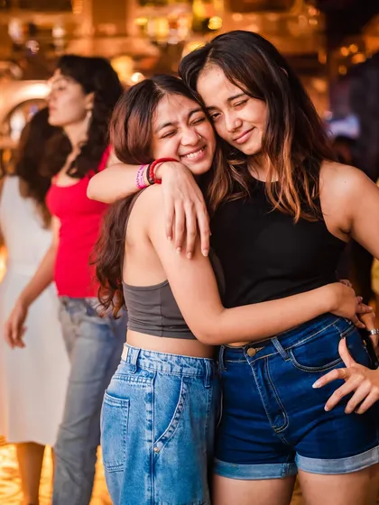Friends sharing a hug and a smile on the dance floor.