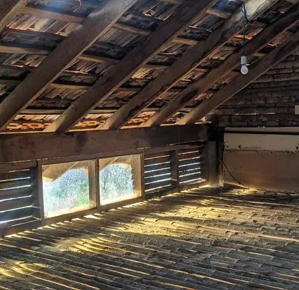 The rustic attic space at Unnathi Farm, with its exposed timber rafters and bamboo floor, is a simple and functional loft.