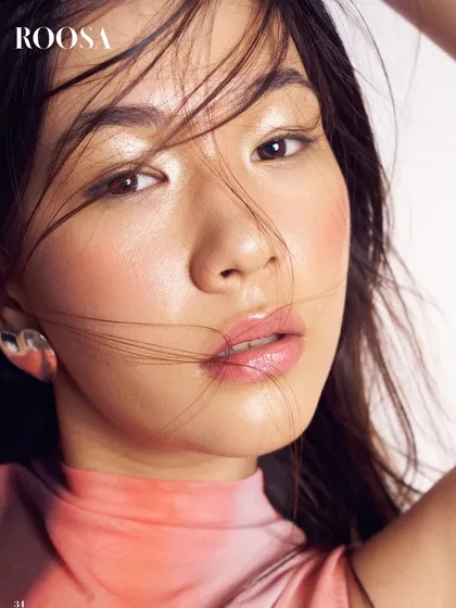 This editorial take on natural beauty features a heavy, dewy blush and glossy lips. The hair is left slightly undone, creating a fresh, windblown effect that feels modern and artistic.
