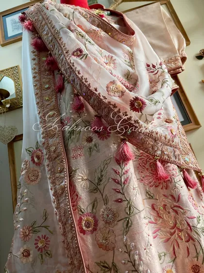 A side view of the mannequin, showing the drape of the dupatta and the embroidered sleeve.