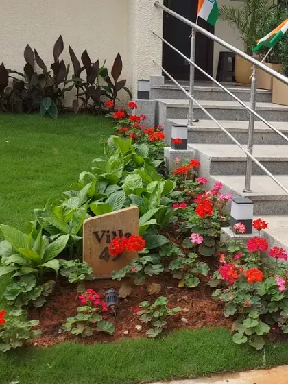 Another view of the Villa 42 entrance, showing how the flower bed and lawn follow the curve of the stairs. This demonstrates careful planning to integrate landscaping with existing structures.