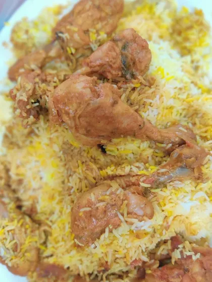 My Chicken Biryani, piled high and ready to serve. You can see the tender chicken drumsticks mixed in with the long-grain basmati rice, cooked with aromatic spices.