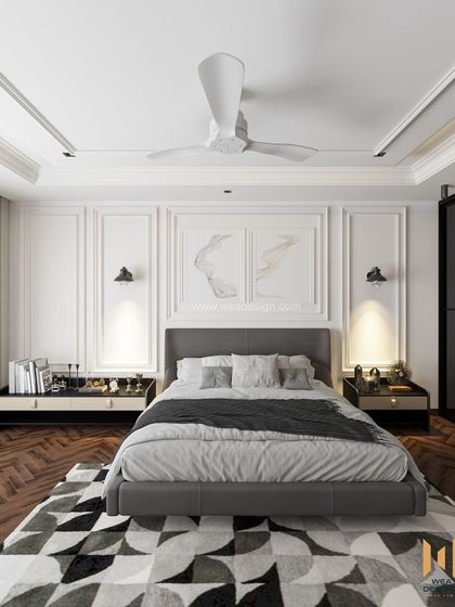 The bed is framed by classic wall mouldings and modern black wall sconces, creating a perfect blend of styles.