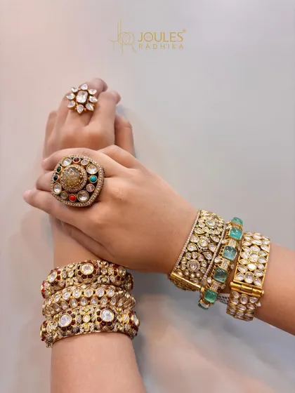Bangles that blend tradition with trend. This image showcases various styles, from emerald-studded kadas to classic polki bangles, paired with statement rings.