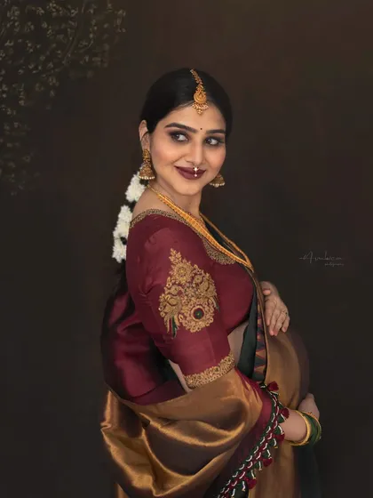 A beautiful profile shot that highlights the intricate details of the embroidered blouse and traditional jewelry. This portrait is a testament to how ethnic attire can create stunning and unique maternity photographs.