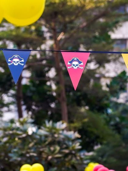 Pirate-themed bunting with skull and crossbones flags strung across the party area.