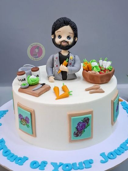 The cake for Karan Kundrra, featuring a custom figurine, a basket of vegetables, and picture frames, all related to his journey on Laughter Chefs.