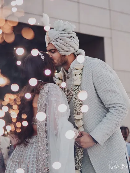 A kiss of love and promise, surrounded by the soft glow of bokeh lights. A truly magical and romantic wedding portrait.