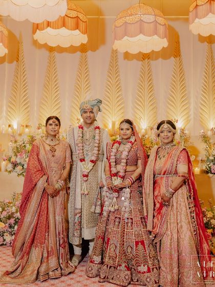 The beautiful family posing against the 'Sitara Mahal' stage. The warm, golden lighting and soft floral arrangements created a perfect backdrop for cherished memories.