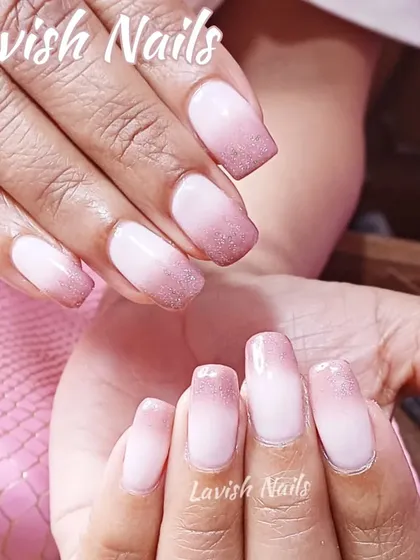 A subtle ombre on natural nails with a light dusting of glitter at the tips.