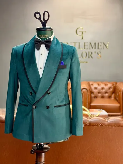 Our bottle green velvet tuxedo on a mannequin, highlighting its double-breasted design and black satin trim. A bold and luxurious choice for any formal event.